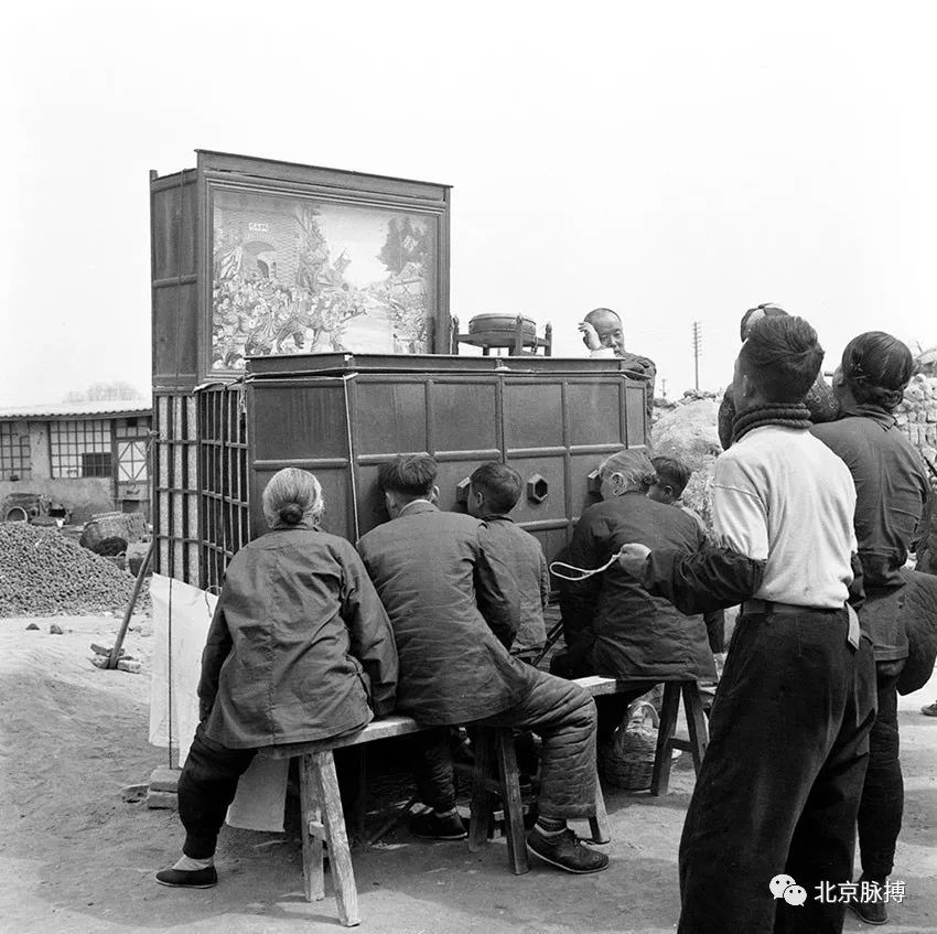 1957年4月，人们在北京蟠桃宫庙会上观看拉样片