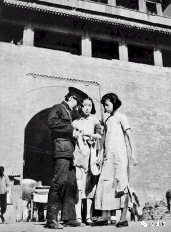 1938年，朝阳门城楼下执勤的女警盘查进出城的女行人。